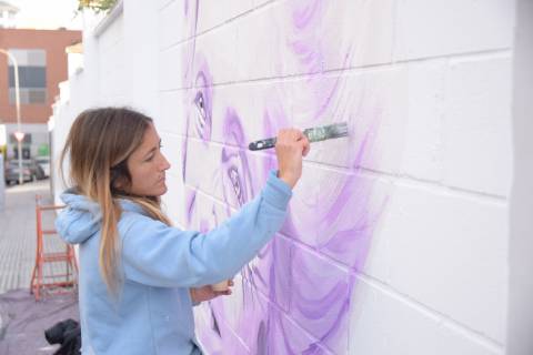 La  artista Velina Lobris realizando uno de los murales sobre mujeres pioneras de la ciencia que se realizó en primavera en paredes de la UPCT.